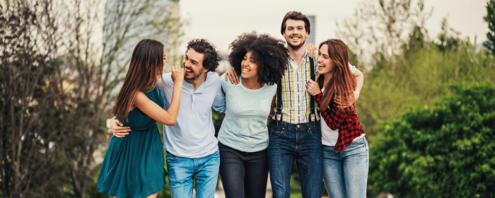 Five young adults smiling and embracing outdoors, symbolizing support and positivity. Offering personalized depression therapy in Centennial, CO.